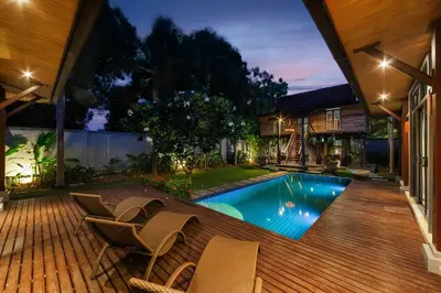 a backyard with a swimming pool with chairs and a house at Villa Bulan with 3BR with Yoga house Nai Harn in Rawai Beach