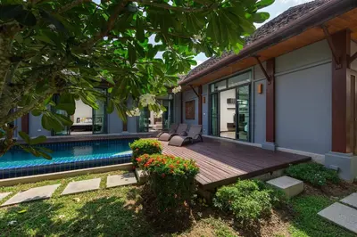 a wooden deck next to a house with a swimming pool at Villa Bulan with 3BR with Yoga house Nai Harn in Rawai Beach