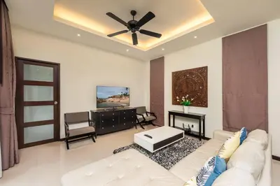 a living room with a white couch and a ceiling fan at Villa Bulan with 3BR with Yoga house Nai Harn in Rawai Beach