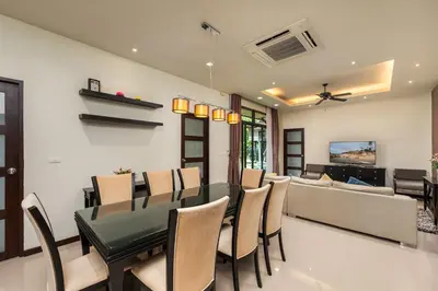 a dining room with a green table and chairs at Villa Bulan with 3BR with Yoga house Nai Harn in Rawai Beach