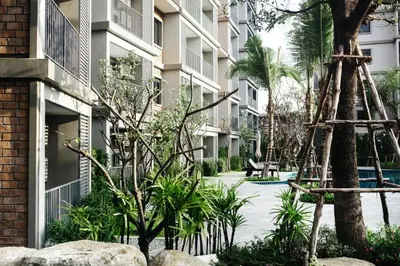 a courtyard with palm trees and a building at The Title Residencies Naiyang by Mill in Nai Yang Beach