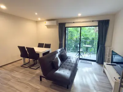 a living room with a couch and a table at The Title Residencies Naiyang by Mill in Nai Yang Beach