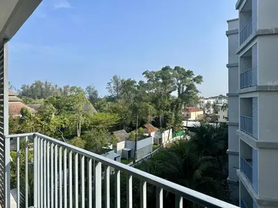 a balcony of a apartment building with trees in the background at The Title Residencies Naiyang F by Mill in Nai Yang Beach