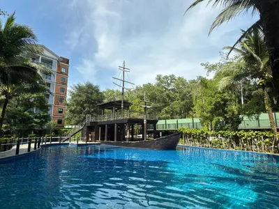 a large swimming pool with a boat in the middle of a building at The Title Residencies Naiyang F by Mill in Nai Yang Beach