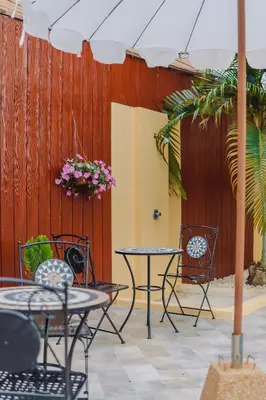 a patio with tables and chairs and a fence at Bauman-Ville Hotel Patong in Patong Beach