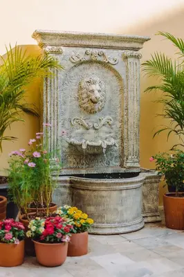 a statue of a lion with flowers in pots at Bauman-Ville Hotel Patong in Patong Beach