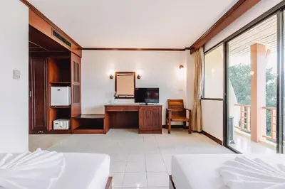 a living room with a television and a mirror at Bauman-Ville Hotel Patong in Patong Beach