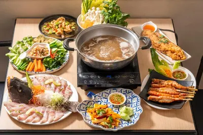 a table topped with plates of food and a pot of food at Horange Phuket Town in Phuket Town