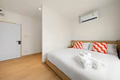 a bedroom with a white bed with towels on it at Horange Phuket Town in Phuket Town
