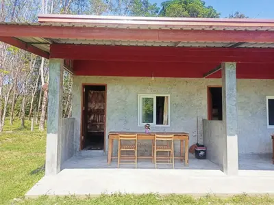 a house with a table and chairs on the porch at Mukda in Ko Yao Noi