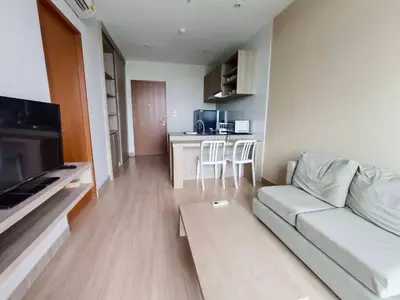a living room with a couch and a kitchen at Condo 1 bed in Phuket City Center 8th Floor in Ban Rangeng