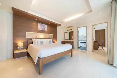 a bedroom with a large bed and a bathroom at Bangtao villa 3 bedroom in Phuket Town