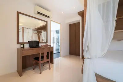 a bedroom with a desk and a bed and a mirror at Bangtao villa 3 bedroom in Phuket Town