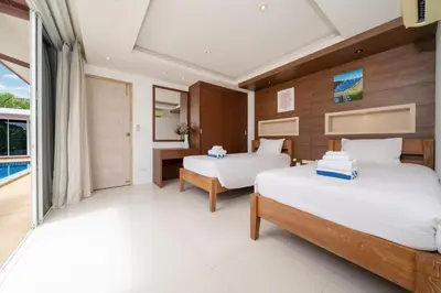 a bedroom with two beds and a balcony at Bangtao villa 3 bedroom in Phuket Town