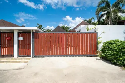 a red gate in front of a house at Bangtao villa 3 bedroom in Phuket Town
