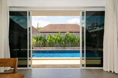 a view of a swimming pool through a sliding glass door at Bangtao villa 3 bedroom in Phuket Town