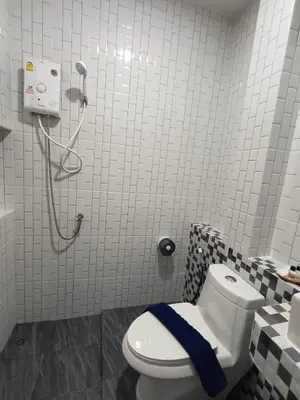 a bathroom with a toilet with a blue towel on it at Hello Montri in Klong Muang Beach