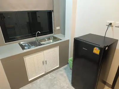 a kitchen with a sink and a black refrigerator at Hello Montri in Klong Muang Beach