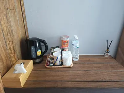 a table with a coffee maker and cups on it at Hello Montri in Klong Muang Beach