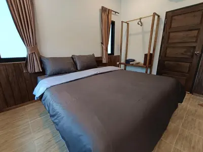 a bedroom with a large bed with a blue blanket at Hello Montri in Klong Muang Beach