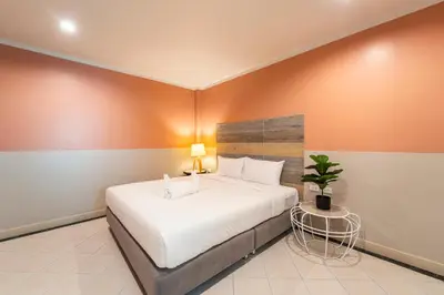 a bedroom with a large bed and a potted plant at Nature's Hideaway by Ratana, Rawai in Ban Saiyuan (1)