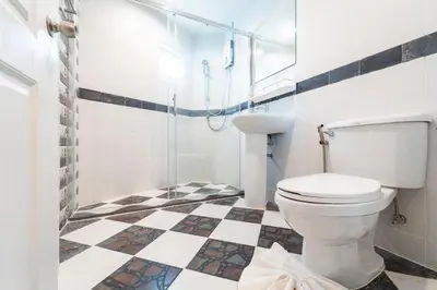 a bathroom with a toilet and a checkered floor at Nature's Hideaway by Ratana, Rawai in Ban Saiyuan (1)