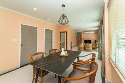 a dining room with a black table and chairs at Nature's Hideaway by Ratana, Rawai in Ban Saiyuan (1)