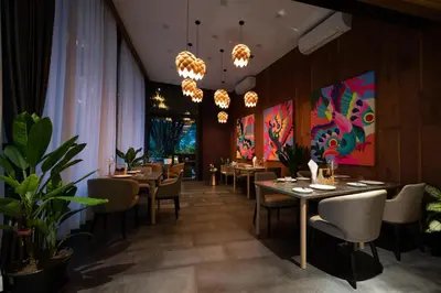 a dining room with tables and chairs and chandeliers at Big Sun Residences By iRETREAT in Ko Yao Noi