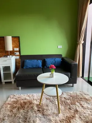 a living room with a couch and a table at Maria's Guest House, Rawai in Rawai Beach