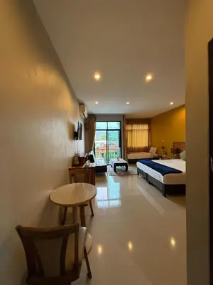 a bedroom with a bed and a table and a desk at Maria's Guest House, Rawai in Rawai Beach