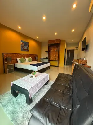 a room with two beds and a couch and a table at Maria's Guest House, Rawai in Rawai Beach