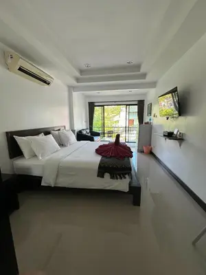 a bedroom with a large bed and a large window at The Seashore Kamala Service Apartment in Kamala Beach