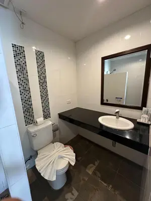 a bathroom with a toilet and a sink and a mirror at The Seashore Kamala Service Apartment in Kamala Beach