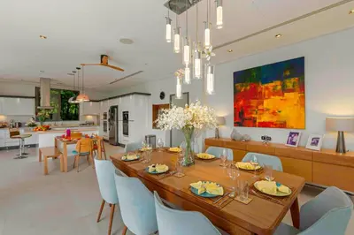 a dining room and kitchen with a table and chairs at Villa White Skies in Khok Kloi