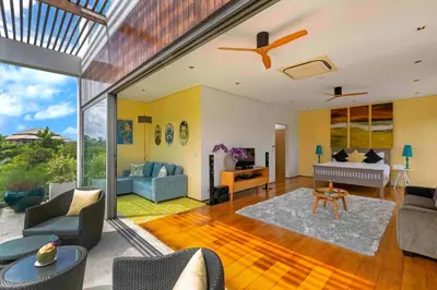 a living room with a couch and a table at Villa White Skies in Khok Kloi