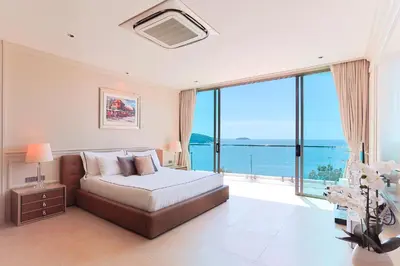 a bedroom with a bed with a view of the ocean at Villa W Collection in Nai Harn Beach