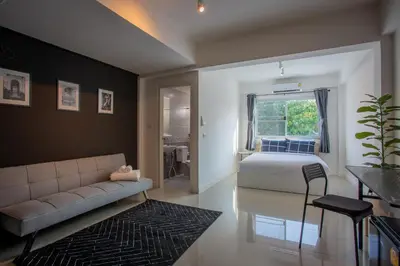 a bedroom with a bed and a couch and a window at Black Turtle in Koh Lone