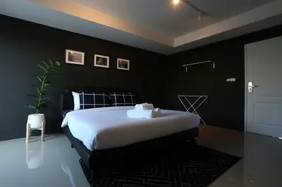 a bedroom with a bed with black walls at Black Turtle in Koh Lone