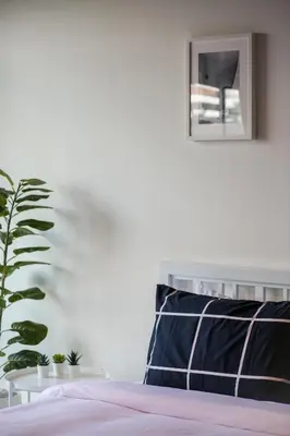 a bed with a black and white pillow and a plant at Black Turtle in Koh Lone