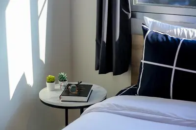 a bedroom with a bed and a table with a clock on it at Black Turtle in Koh Lone