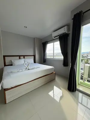 a bedroom with a bed and a large window at ZEN Hotel Patong Beach -ex- miami Production in Patong Beach