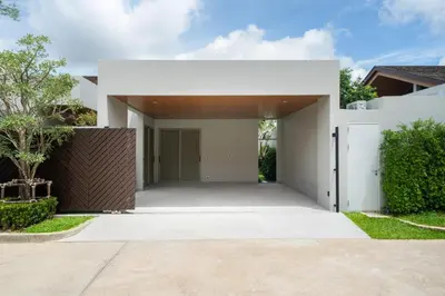 a white house with a driveway at Villa private swimming pool and garden in Phuket Town