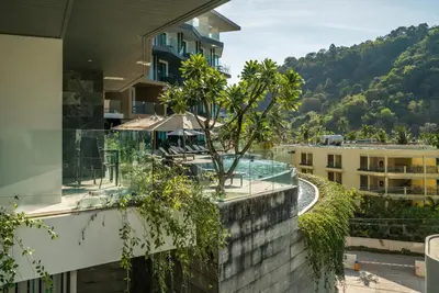a building with a tree on the side of it at Private sea view studio at Twin Sands in Patong Beach