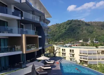 a hotel with a swimming pool and a mountain at Private sea view studio at Twin Sands in Patong Beach
