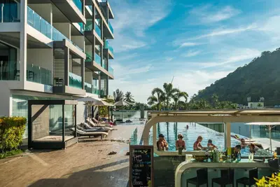 a resort with a pool and people in the water at Private sea view studio at Twin Sands in Patong Beach