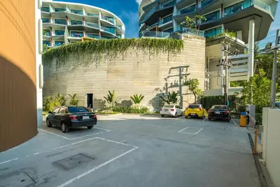 a parking lot with cars parked in front of a building at Private sea view studio at Twin Sands in Patong Beach
