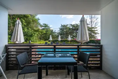 a patio with a table and chairs and umbrellas at Pool view studio at Nakalay Palm by Lofty in Kamala Beach