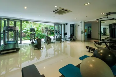 a gym with several exercise equipment in a room at Pool view studio at Nakalay Palm by Lofty in Kamala Beach