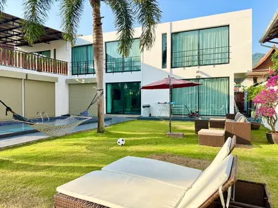 a backyard with a hammock and a house at The White House Kamala Phuket in Kamala Beach