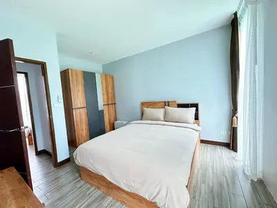 a bedroom with a large bed with white sheets at The White House Kamala Phuket in Kamala Beach